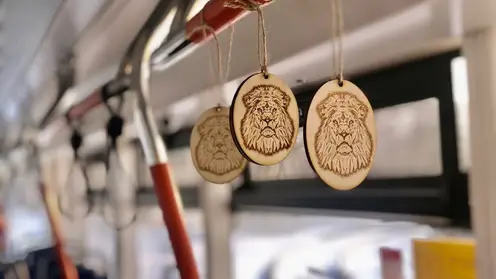 В салонах новых красноярских трамваев повесили сувениры с изображением львов