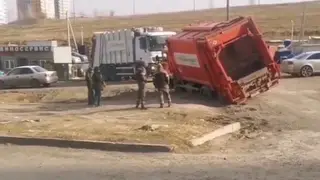 В Красноярске мусоровоз провалился в яму при выезде со двора